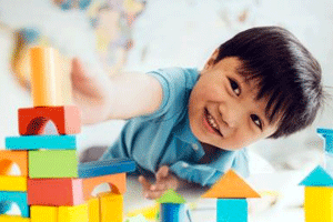 Preschool daycare program with kid playing with building blocks