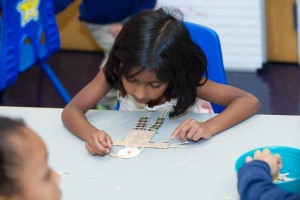 A preschool girl draws a picture during a daycare session in Columbus Ohio