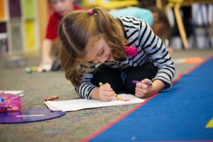 A preschool girl draws a picture during a daycare session in Columbus Ohio